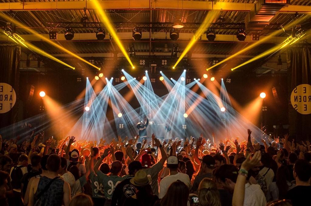 Concert stage with dramatic lighting and crowd silhouettes